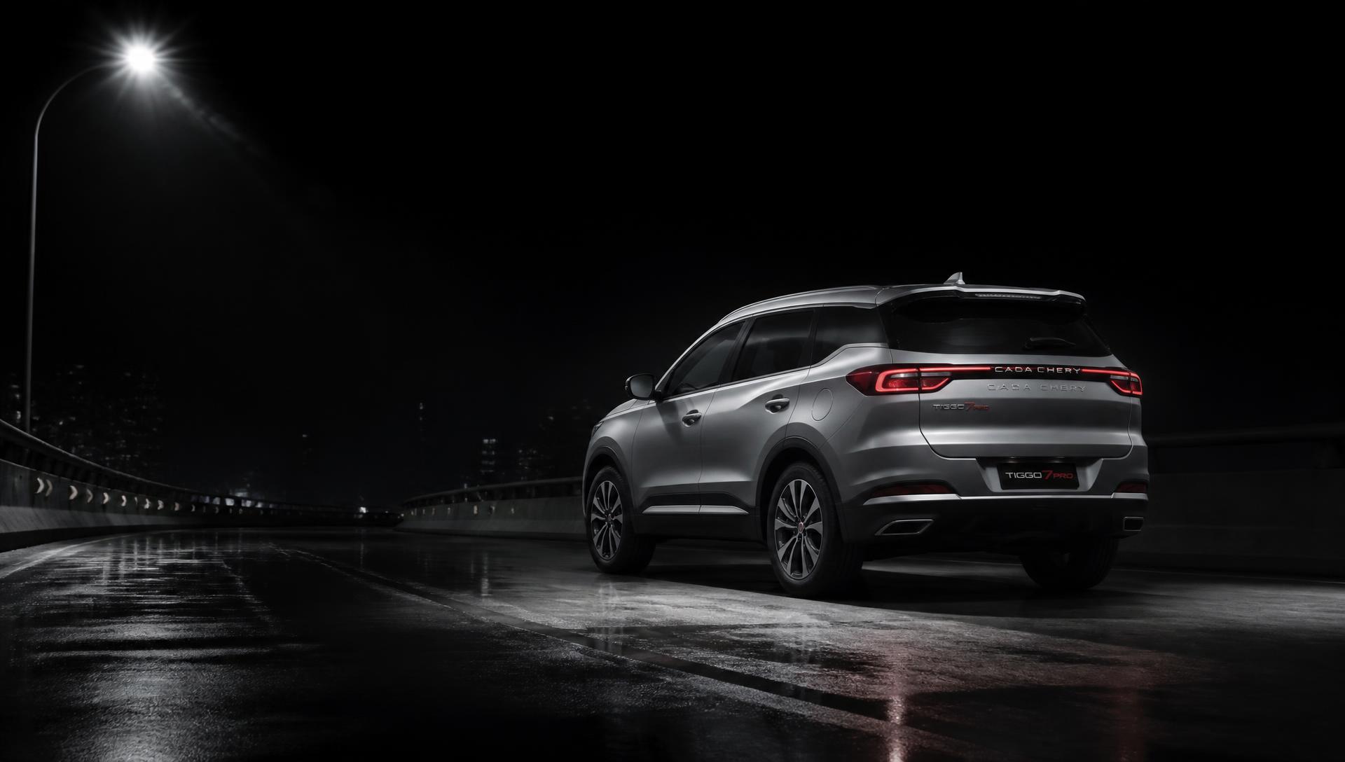 SUV prateado em viaduto à noite, fotografia automotiva editorial